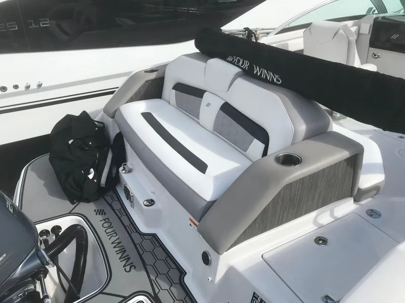 Slide: The Image of 2017 Four Winns HD220 OB boat interior with cushioned seating and branded flooring. - 19