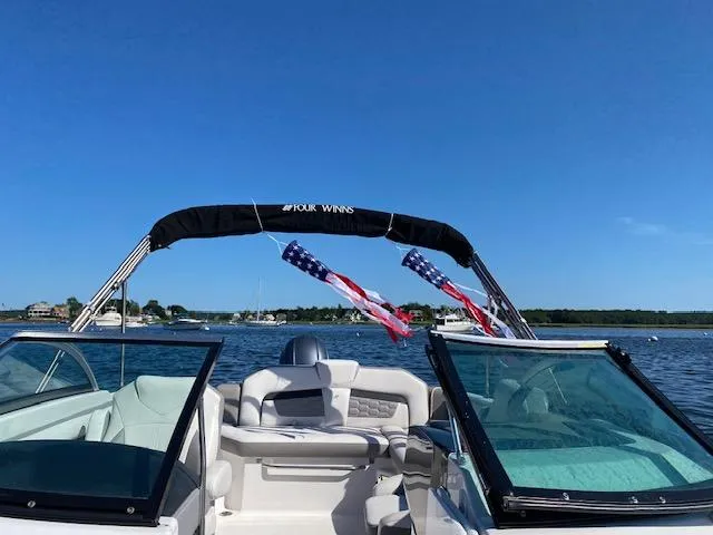 Slide: The Image of 2017 Four Winns HD220 OB boat on a sunny lake with American flags. - 5