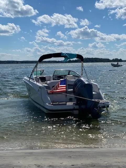 Slide: The Image of 2017 Four Winns HD220 OB boat docked on a sunny beach with an American flag. - 6