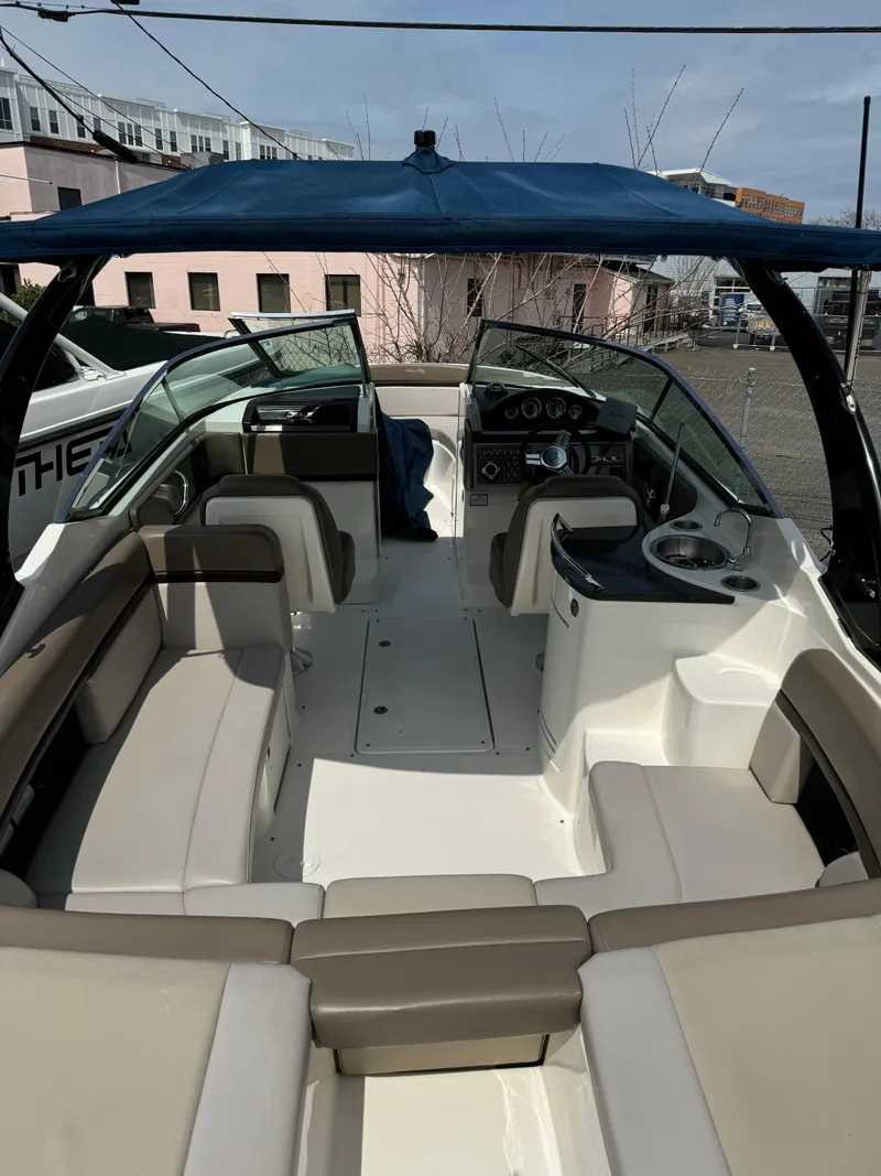 Slide: The Image of 2013 Sea Ray 270 SLX boat interior with seating and helm, docked under blue canopy. - 10