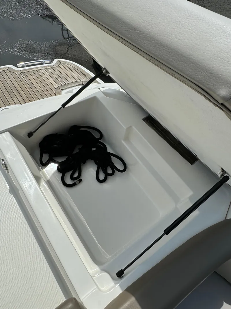 Slide: The Image of Open storage compartment on 2013 Sea Ray 270 SLX boat with black ropes inside. - 18