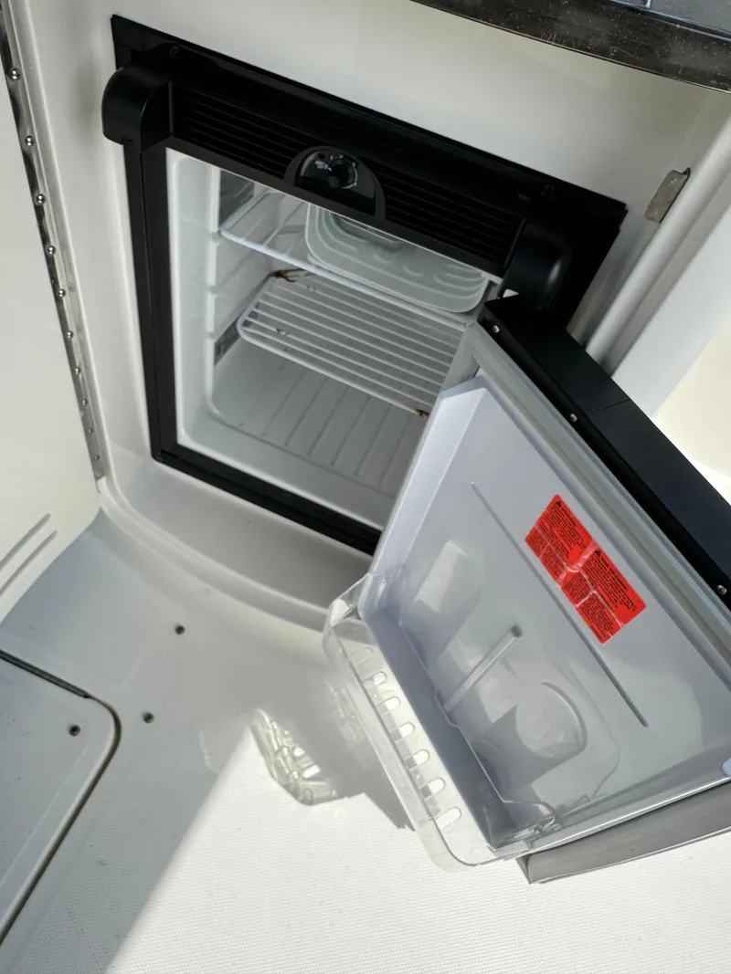 Slide: The Image of Open mini fridge on 2013 Sea Ray 270 SLX boat, showing interior shelves. - 24