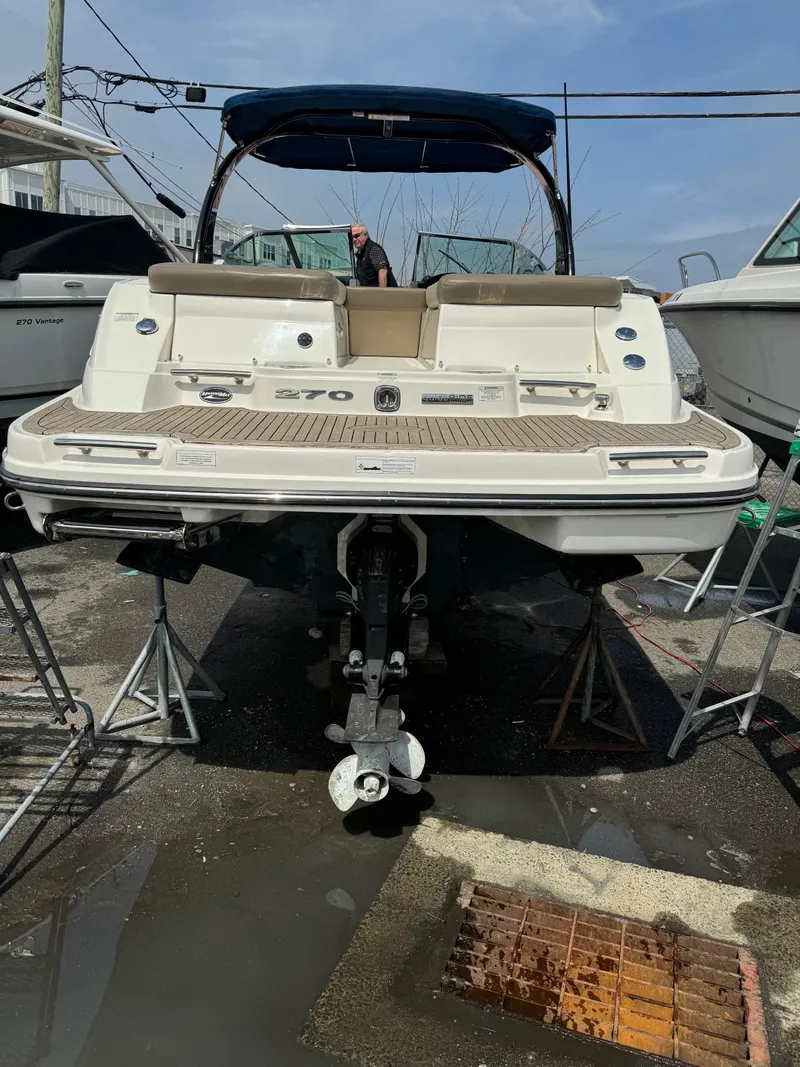 Slide: The Image of 2013 Sea Ray 270 SLX boat on stands, rear view, in a marina setting. - 27