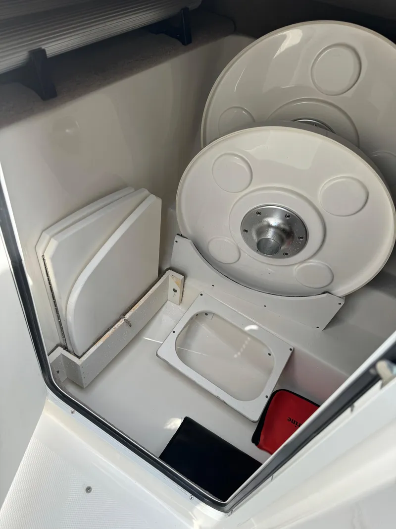 Slide: The Image of 2013 Sea Ray 270 SLX boat storage compartment with life ring and safety equipment. - 28