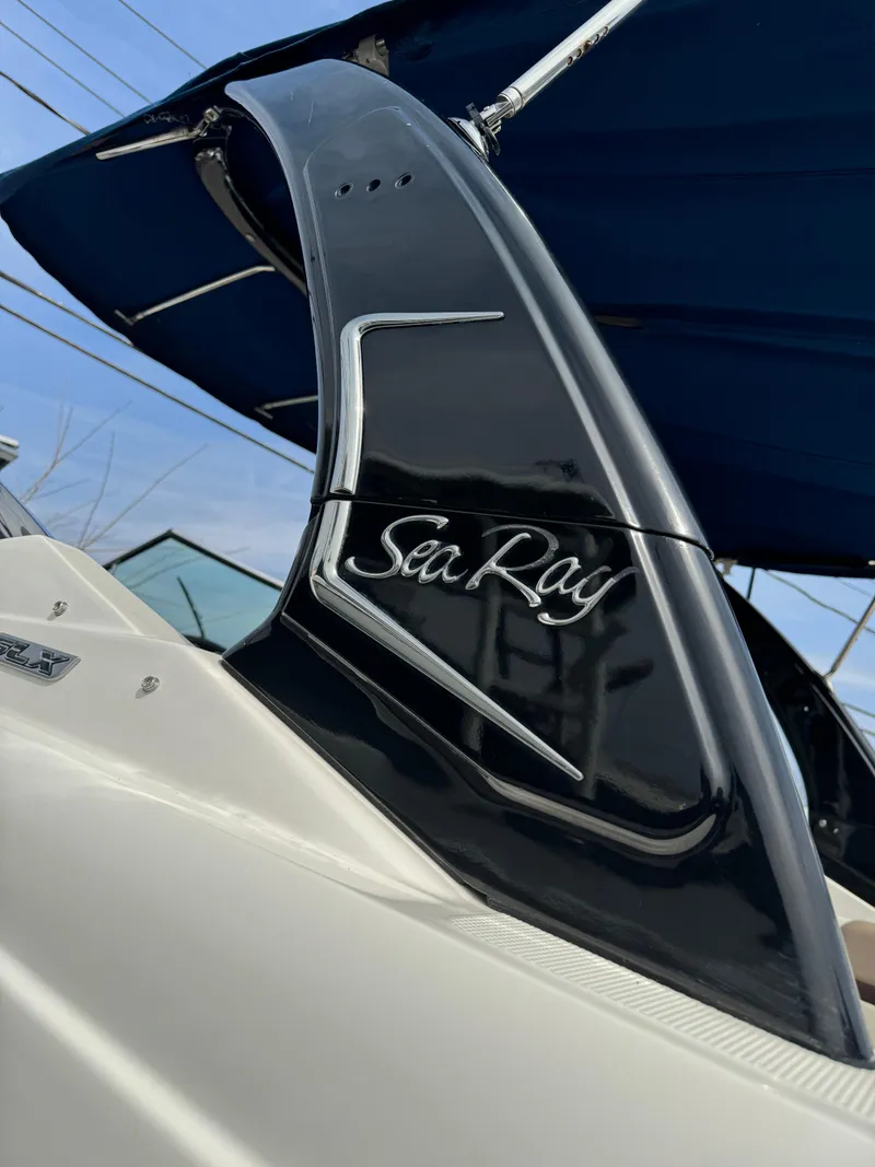 Slide: The Image of 2013 Sea Ray 270 SLX boat with sleek black detailing and canopy. - 29