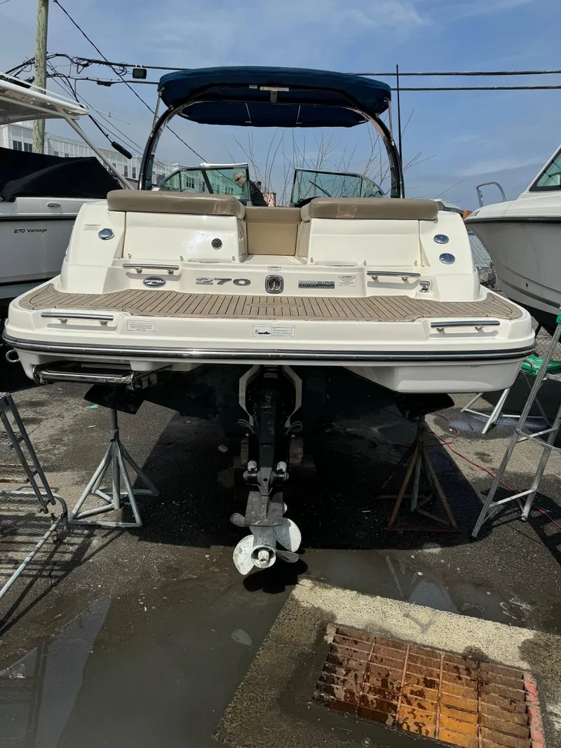 Slide: The Image of 2013 Sea Ray 270 SLX boat on stands, rear view, in a marina setting. - 3