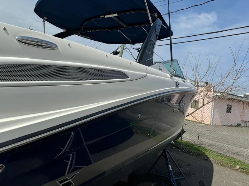 Slide: The Image of 2013 Sea Ray 270 SLX boat with blue hull and canopy, docked outdoors. - 4
