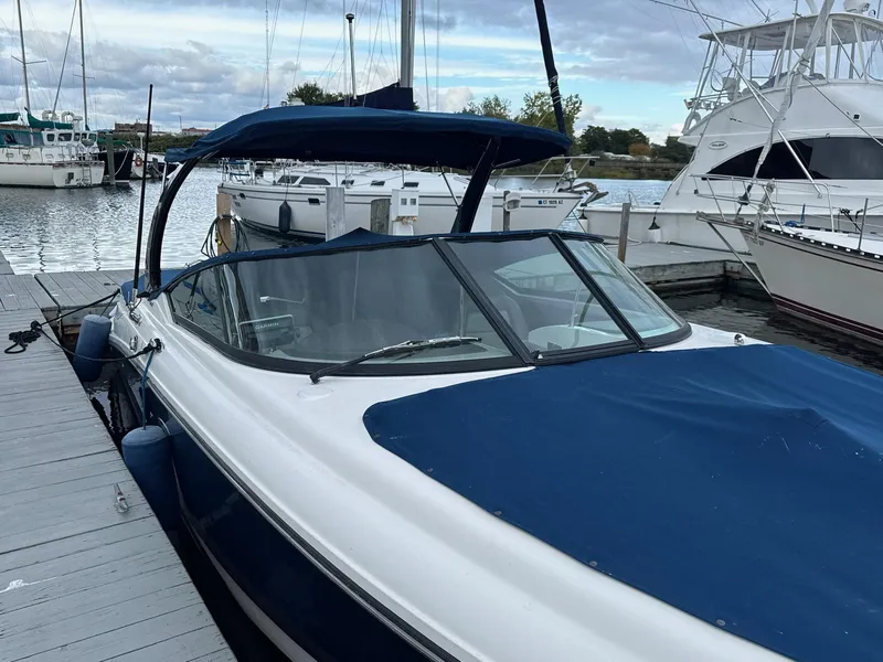 Slide: The Image of 2013 Sea Ray 270 SLX boat docked at marina with blue cover. - 5