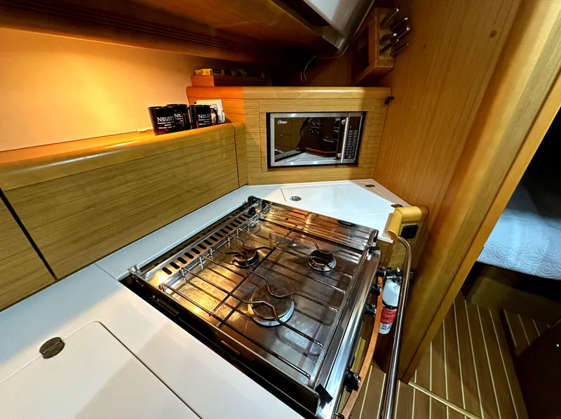 Slide: The Image of Galley kitchen in 2010 Jeanneau Sun Odyssey 50 DS sailboat with stove and microwave. - 32