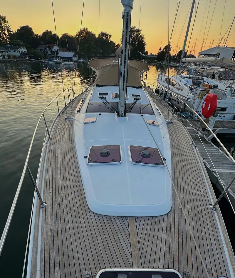 Slide: The Image of 2010 Jeanneau Sun Odyssey 50 DS sailboat docked at sunset, featuring a spacious deck. - 6