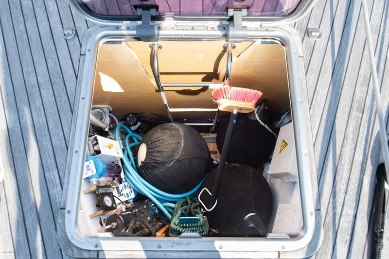 Slide: The Image of Storage compartment on 2010 Jeanneau Sun Odyssey 50 DS sailboat, containing various nautical equipment. - 72