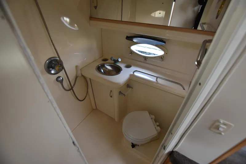 Slide: The Image of 2001 Larson Cabrio 330 boat bathroom with sink, toilet, and showerhead. - 25