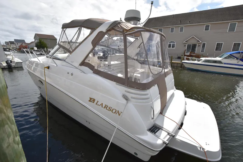 Slide: The Image of 2001 Larson Cabrio 330 boat docked in a marina, featuring a covered cockpit. - 5