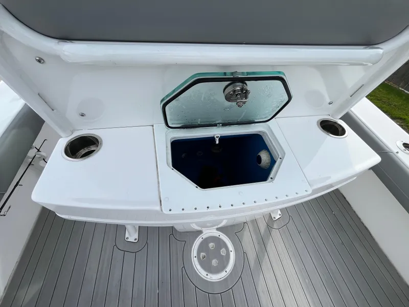Slide: The Image of 2023 Everglades 253 Center Console boat interior with storage compartment and cup holders. - 12