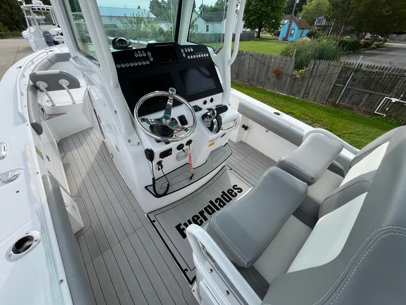 Slide: The Image of 2023 Everglades 253 Center Console boat interior with steering wheel and seating. - 13