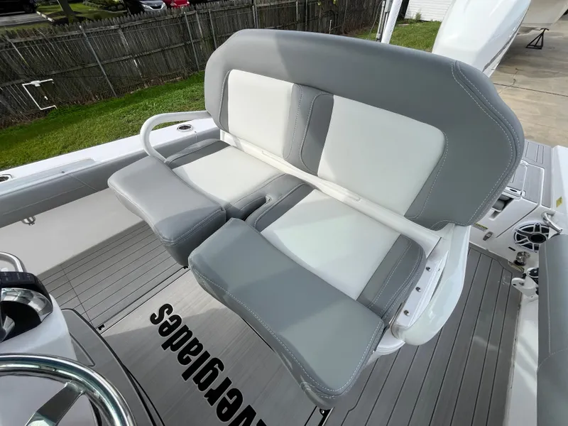 Slide: The Image of 2023 Everglades 253 Center Console boat seating, gray and white upholstery, outdoor setting. - 15