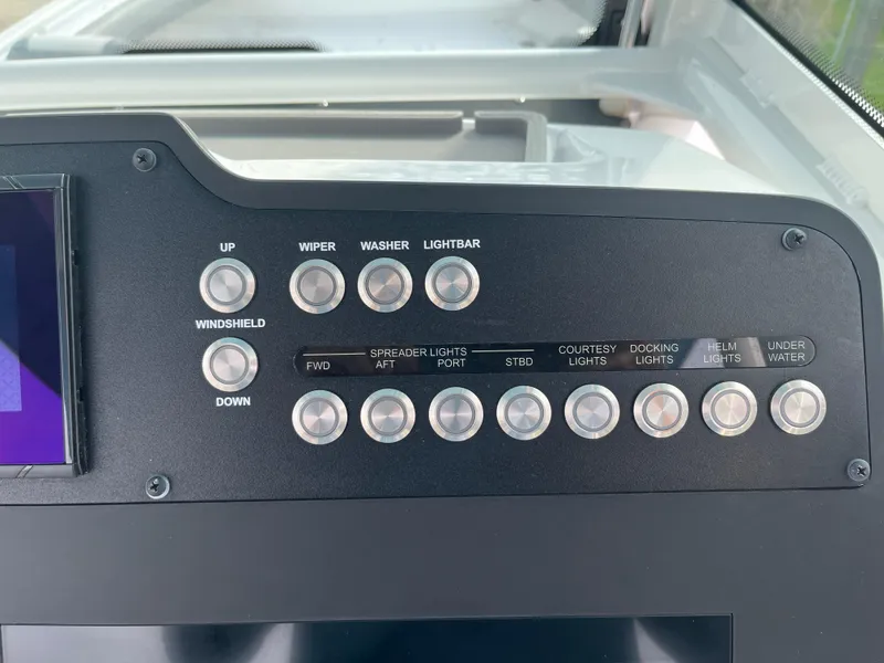 Slide: The Image of Control panel of 2023 Everglades 253 Center Console boat with various switches. - 18