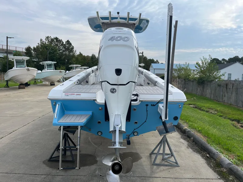 Slide: The Image of 2023 Everglades 253 Center Console boat on stands, rear view, blue and white design. - 2