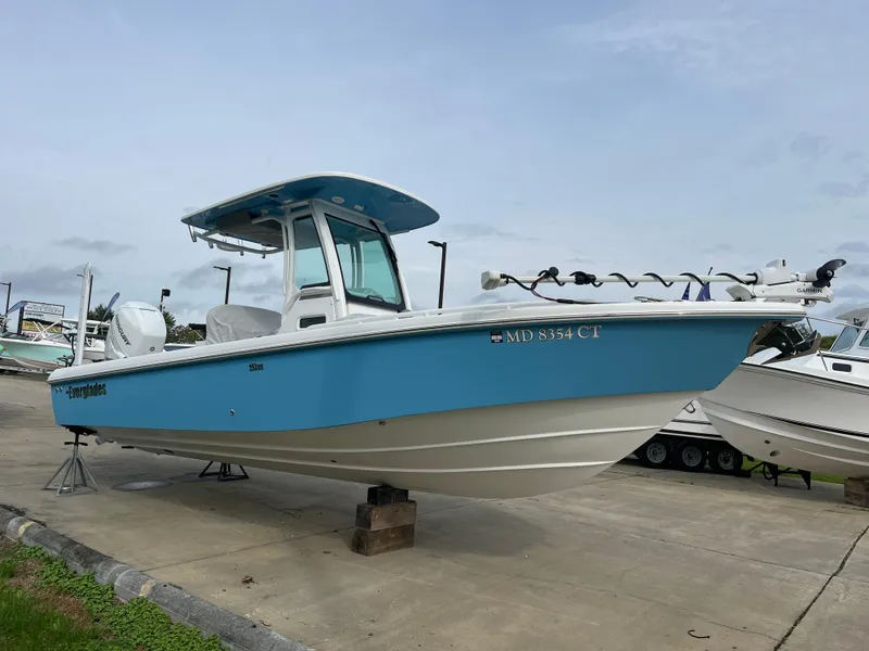 Slide: The Image of 2023 Everglades 253 Center Console boat, blue hull, parked on concrete. - 4