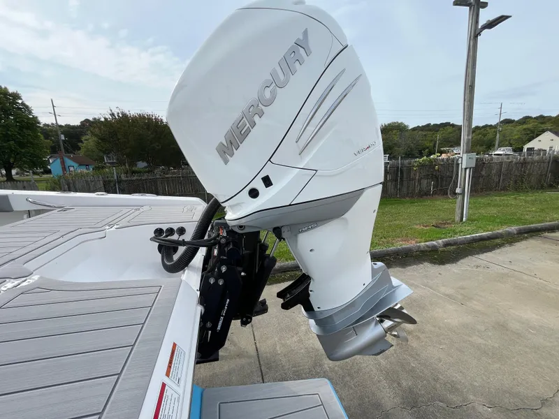 Slide: The Image of 2023 Everglades 253 Center Console with Mercury outboard engine, parked outdoors. - 5