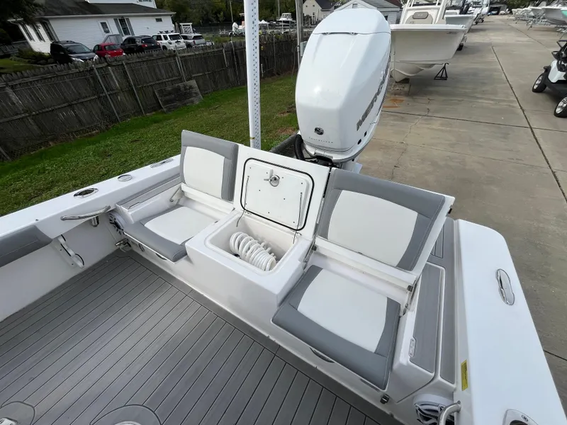 Slide: The Image of 2023 Everglades 253 Center Console boat with cushioned seating and outboard motor. - 8