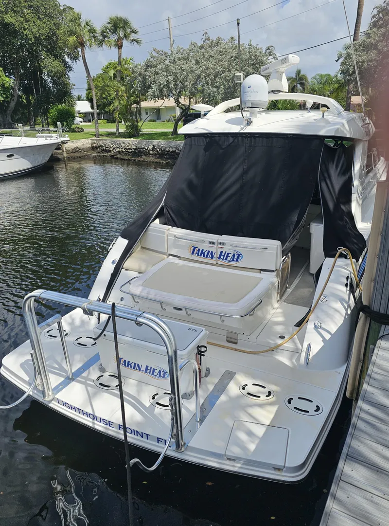 Slide: The Image of 2012 Sea Ray SUNDANCE yacht docked, featuring a sleek design and spacious deck area. - 1