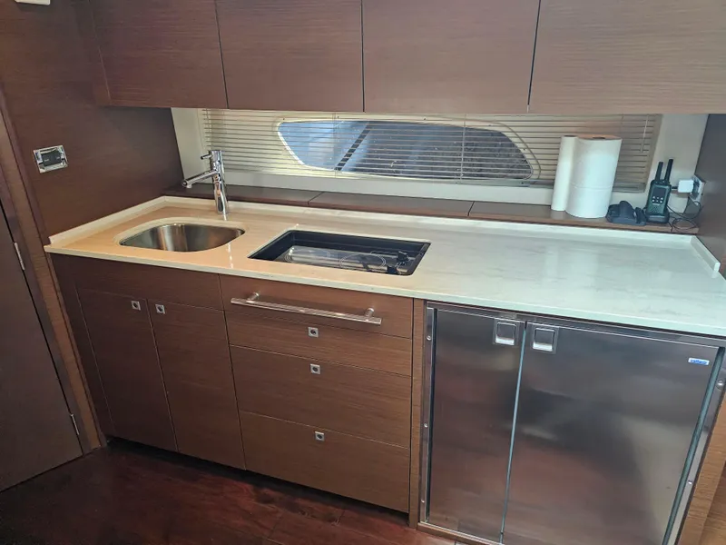 Slide: The Image of Modern kitchen area in a 2012 Sea Ray SUNDANCE yacht, featuring sleek cabinetry and appliances. - 11
