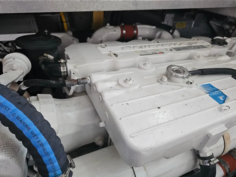 Slide: The Image of Engine compartment of 2012 Sea Ray SUNDANCE boat, showcasing white engine components. - 19