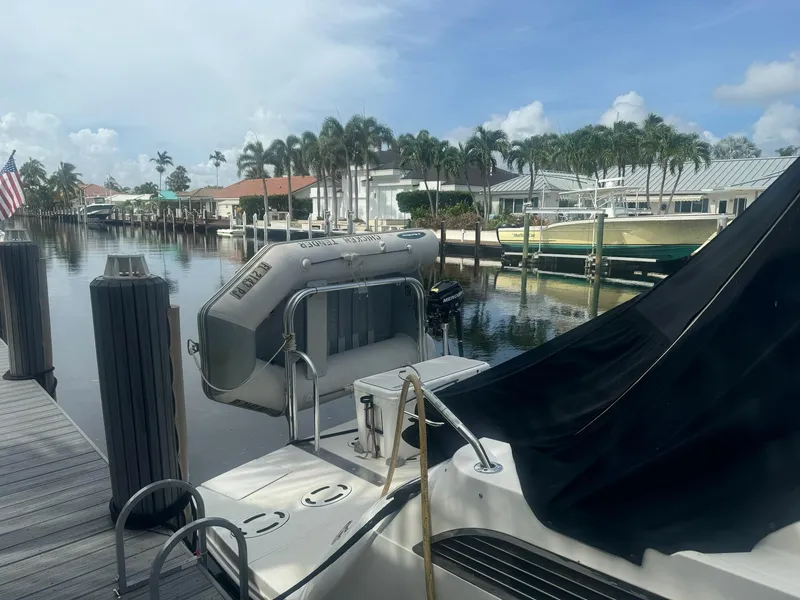 Slide: The Image of 2012 Sea Ray SUNDANCE docked in a scenic marina with palm trees and waterfront homes. - 26