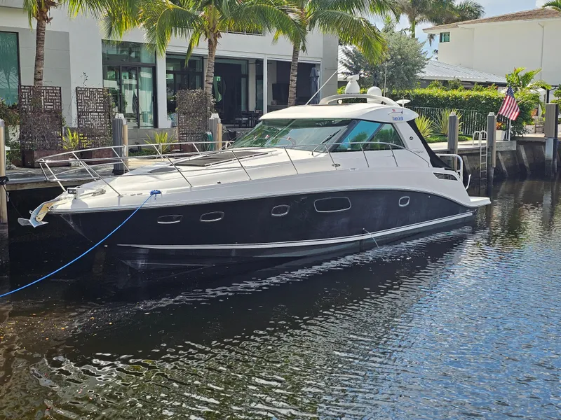 Slide: The Image of 2012 Sea Ray SUNDANCE yacht docked by waterfront home with palm trees. - 28