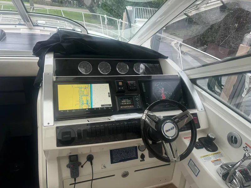Slide: The Image of 2012 Sea Ray SUNDANCE helm with navigation screens and steering wheel. - 3