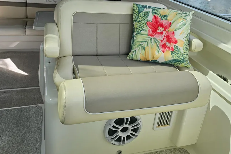 Slide: The Image of 2012 Sea Ray SUNDANCE boat interior with beige seating and floral cushion. - 9