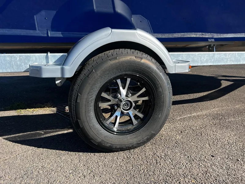 Slide: The Image of 2025 Fish Rite Angler 18 trailer wheel on asphalt pavement. - 12