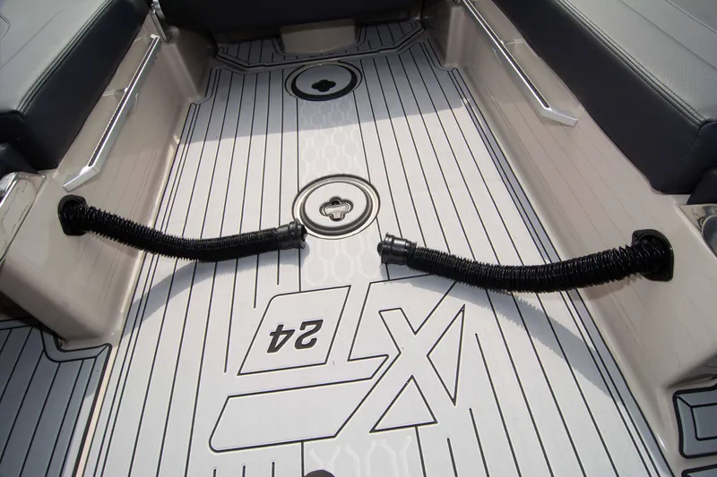 Slide: The Image of 2025 MasterCraft XT24 boat interior with sleek flooring design and seating. - 25