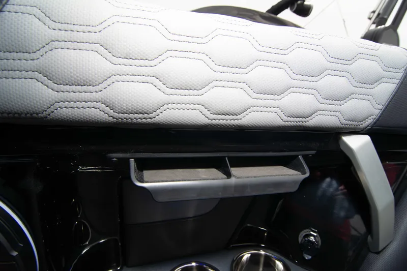 Slide: The Image of 2025 MasterCraft XT24 interior detail with hexagonal seat pattern and storage compartment. - 27