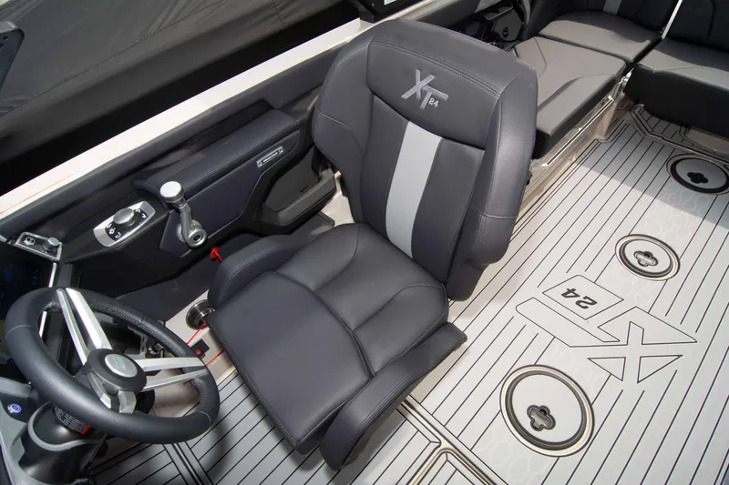 Slide: The Image of 2025 MasterCraft XT24 boat interior with sleek seating and modern steering wheel design. - 39