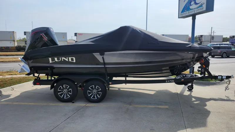 Slide: The Image of 2025 Lund 189 Tyee GL boat on trailer, covered and parked outdoors. - 13