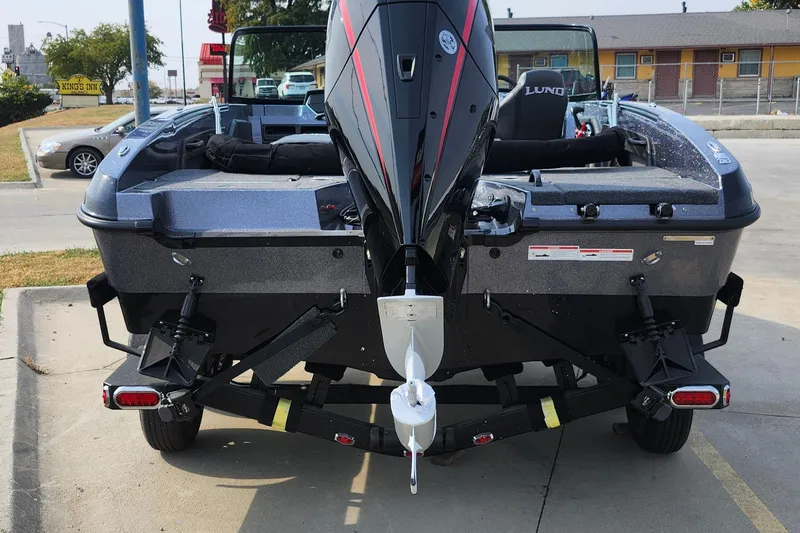 Slide: The Image of 2025 Lund 189 Tyee GL boat rear view with motor, parked on trailer. - 22