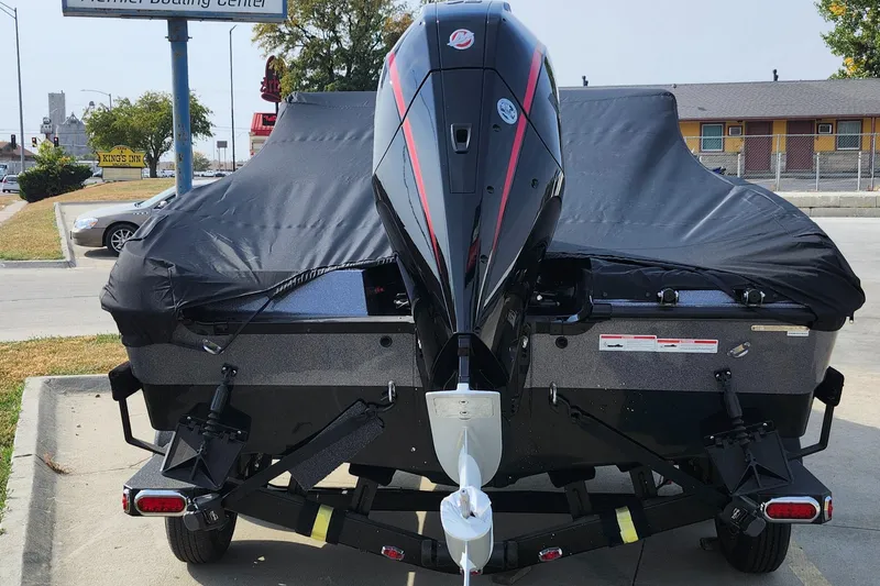 Slide: The Image of 2025 Lund 189 Tyee GL boat with cover and outboard motor, parked outdoors. - 28