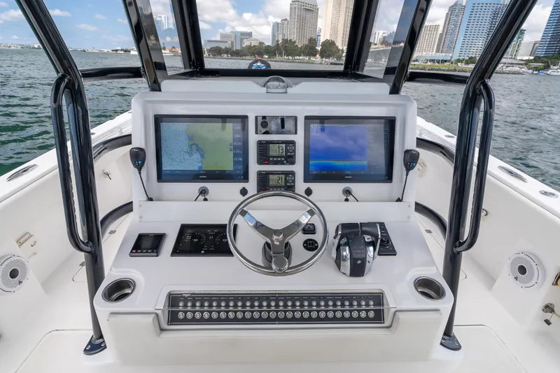 Slide: The Image of Invincible 35 Catamaran 2020 helm with dual screens and city skyline in background. - 13