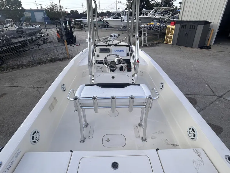 Slide: The Image of 2013 Skeeter SX2250 boat interior with steering console and seating, parked in a marina. - 10