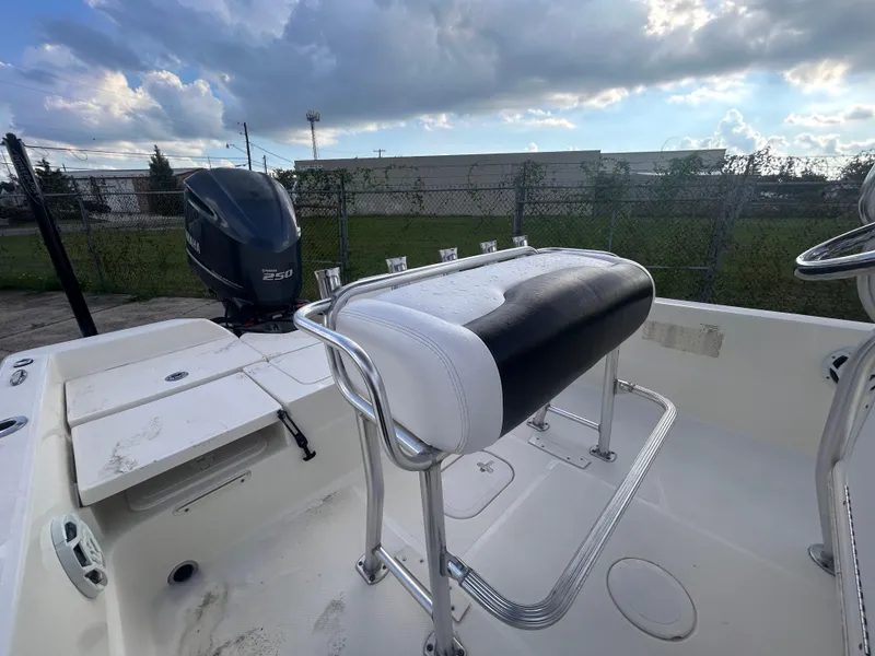 Slide: The Image of 2013 Skeeter SX2250 boat interior with seating and outboard motor, under a cloudy sky. - 13