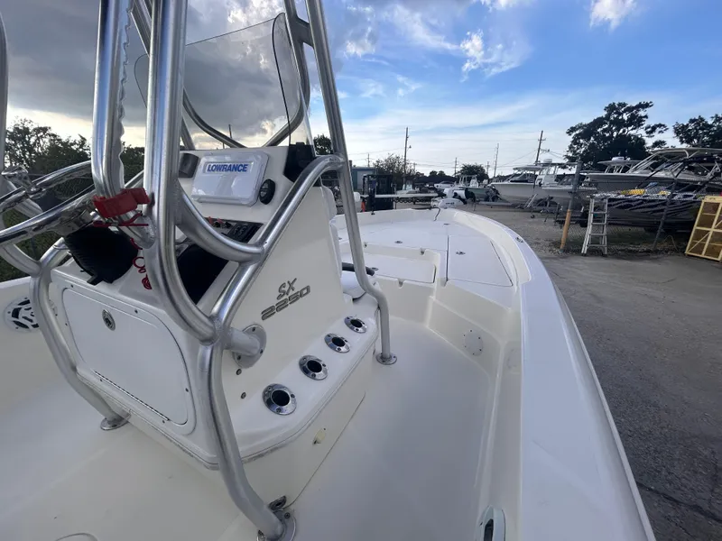 Slide: The Image of 2013 Skeeter SX2250 boat with console and rod holders, docked under a cloudy sky. - 14