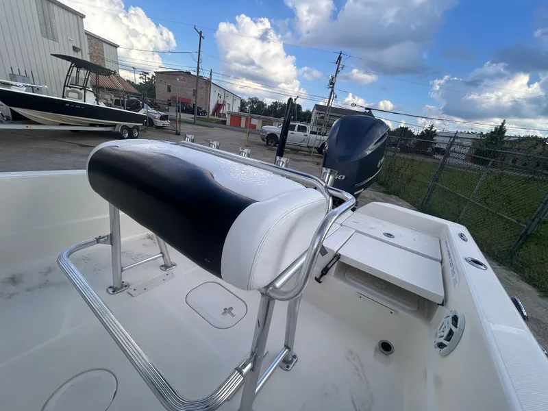 Slide: The Image of 2013 Skeeter SX2250 boat interior with seating and motor, parked outdoors under a cloudy sky. - 16