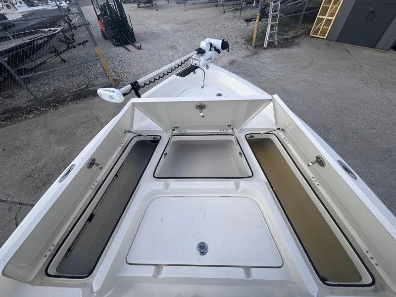 Slide: The Image of 2013 Skeeter SX2250 boat with open storage compartments, parked in a marina. - 20