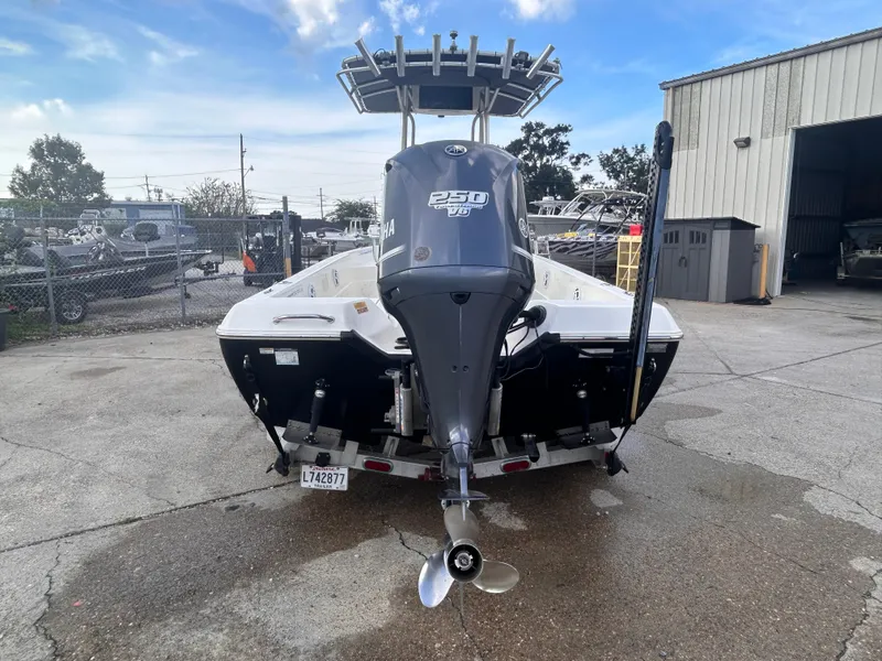 Slide: The Image of 2013 Skeeter SX2250 boat with Yamaha 250 HP engine, parked outdoors near a warehouse. - 5