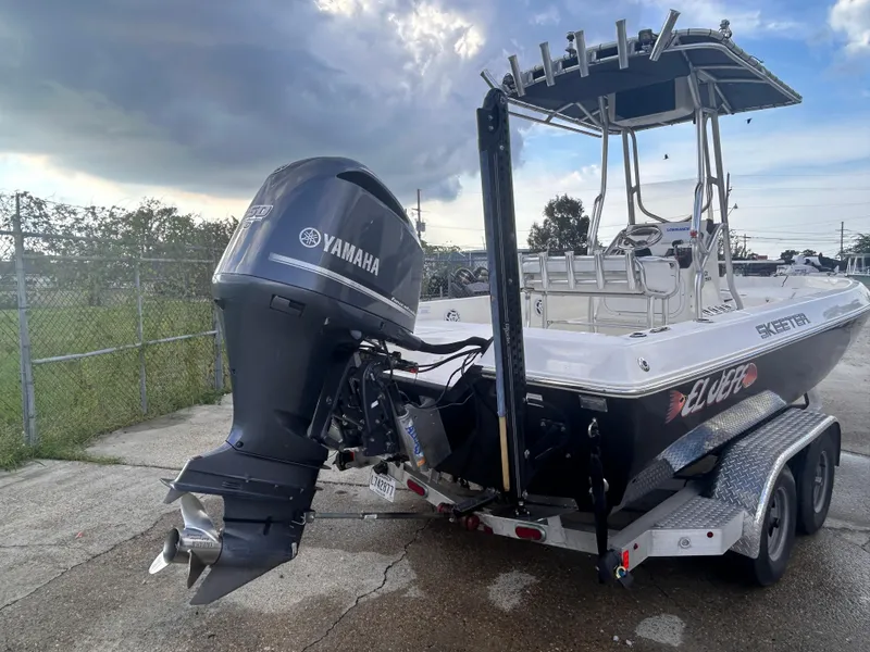 Slide: The Image of 2013 Skeeter SX2250 boat with Yamaha outboard motor on a trailer, parked outdoors. - 6