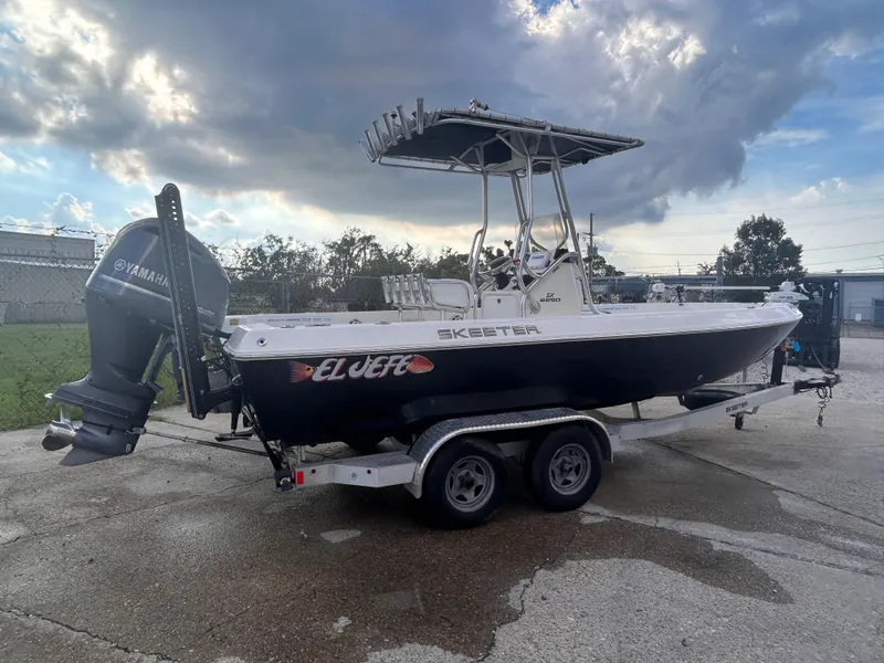 Slide: The Image of 2013 Skeeter SX2250 boat on trailer with Yamaha outboard motor, parked outdoors under cloudy sky. - 7