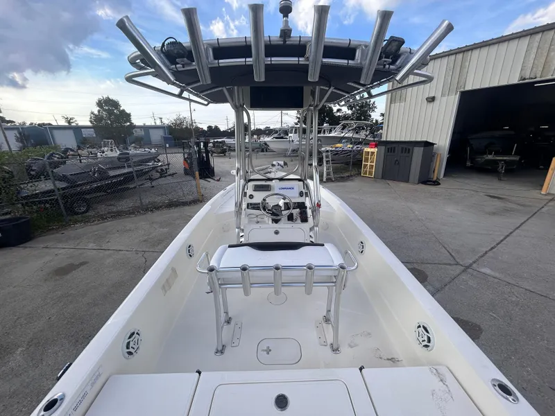 Slide: The Image of 2013 Skeeter SX2250 boat with T-top, parked outdoors near a warehouse. - 9