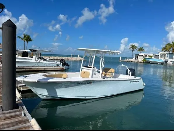 The Image of 2021 Sportsman Heritage 231 Center Console boat docked in a sunny marina. - 1
